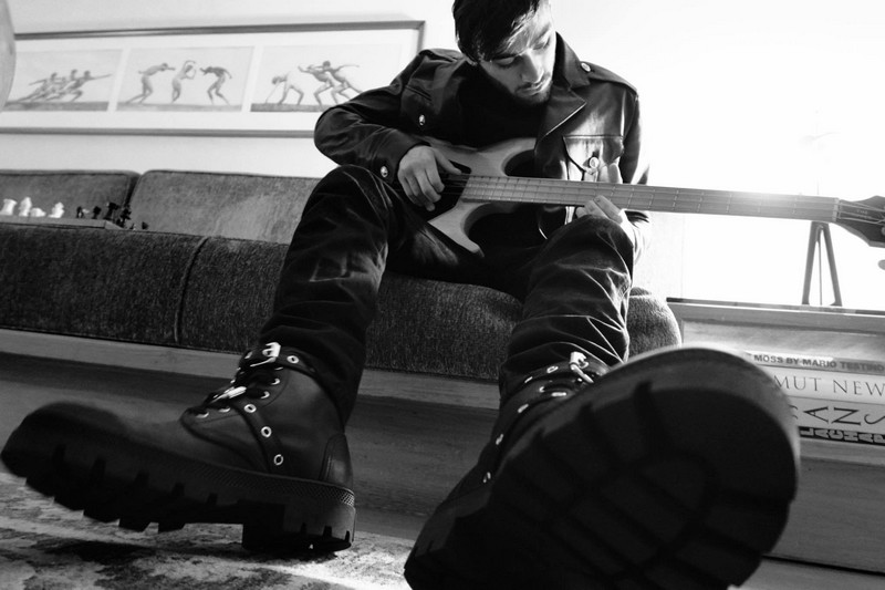 ZaynMalik playing guitar in a Versus biker leather jacket